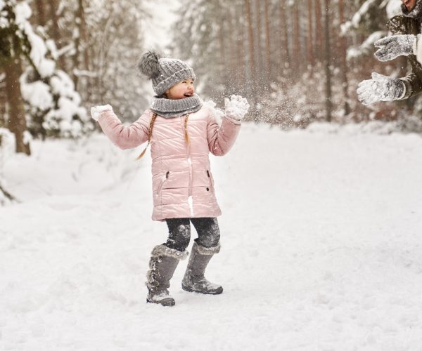 Little girl during a snowball fight in the snow